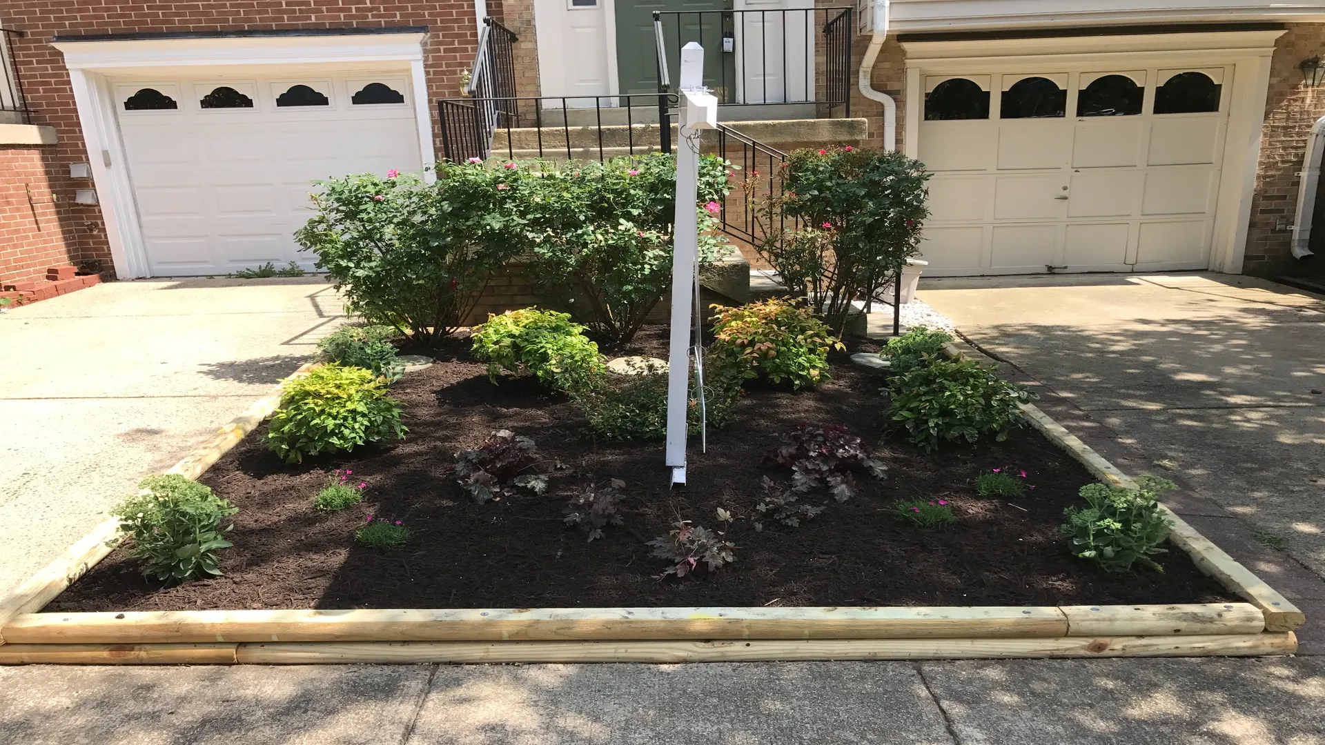 Neatly landscaped townhouse front yard with new plants.